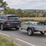 Assurance remorque : couverte par votre auto ou contrat à part ? Remorque à ridelles basses attelée à un break gris foncé sur